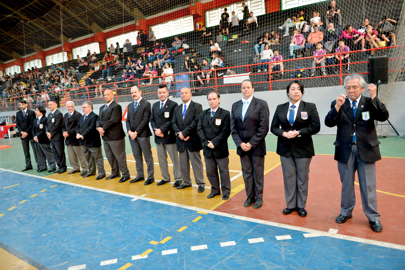 Um grupo de pessoas em uma quadra de basquete mostrando a qualidade e a força da competição regional de judô.