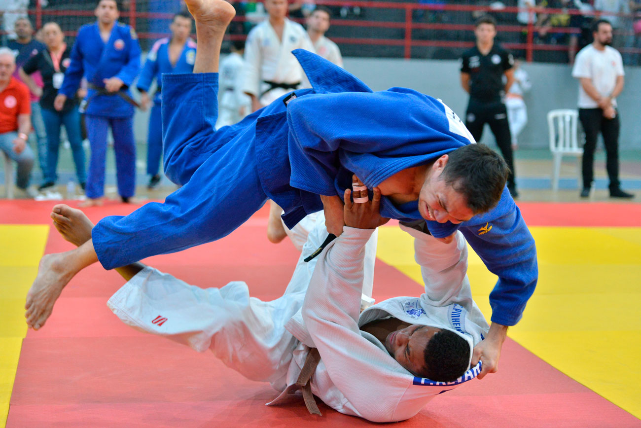 Um homem mostra suas habilidades de jiu jitsu durante uma competição.